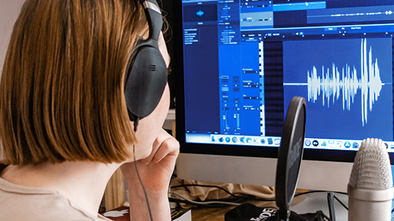 Mujer grabando y editando audio para ilustrar la normalización del sonido de un vídeo