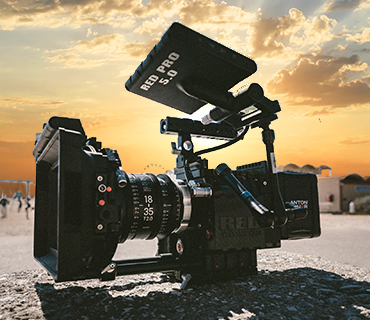 Film camera in front of a sunset over the ocean