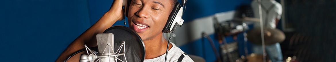 Singer with headphones in front of a mic